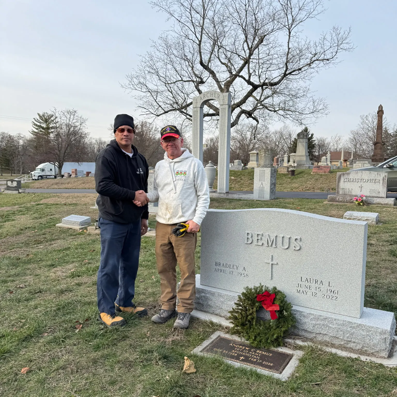 two members of TOMCO at a grave