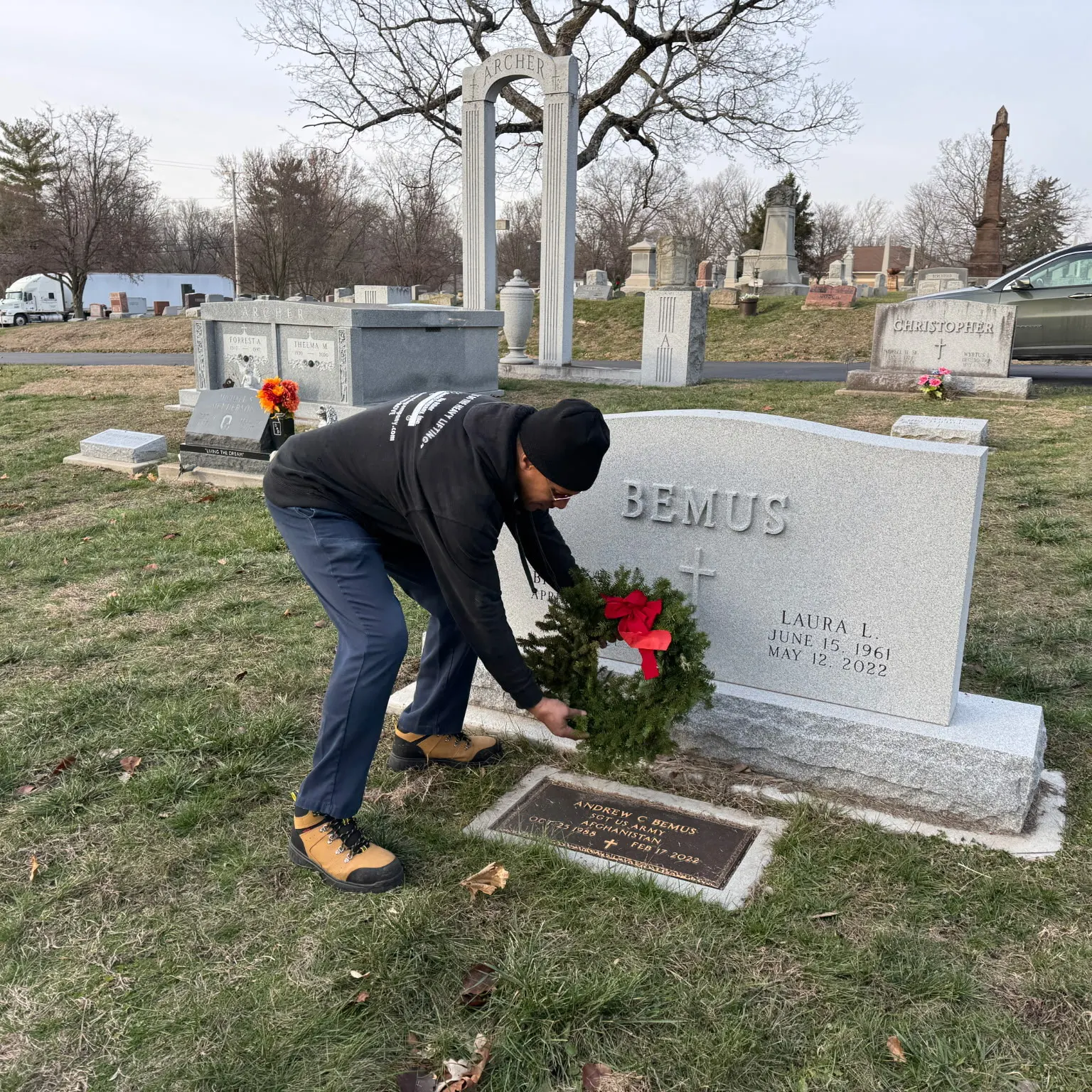 a member of TOMCO places flowers on a grave