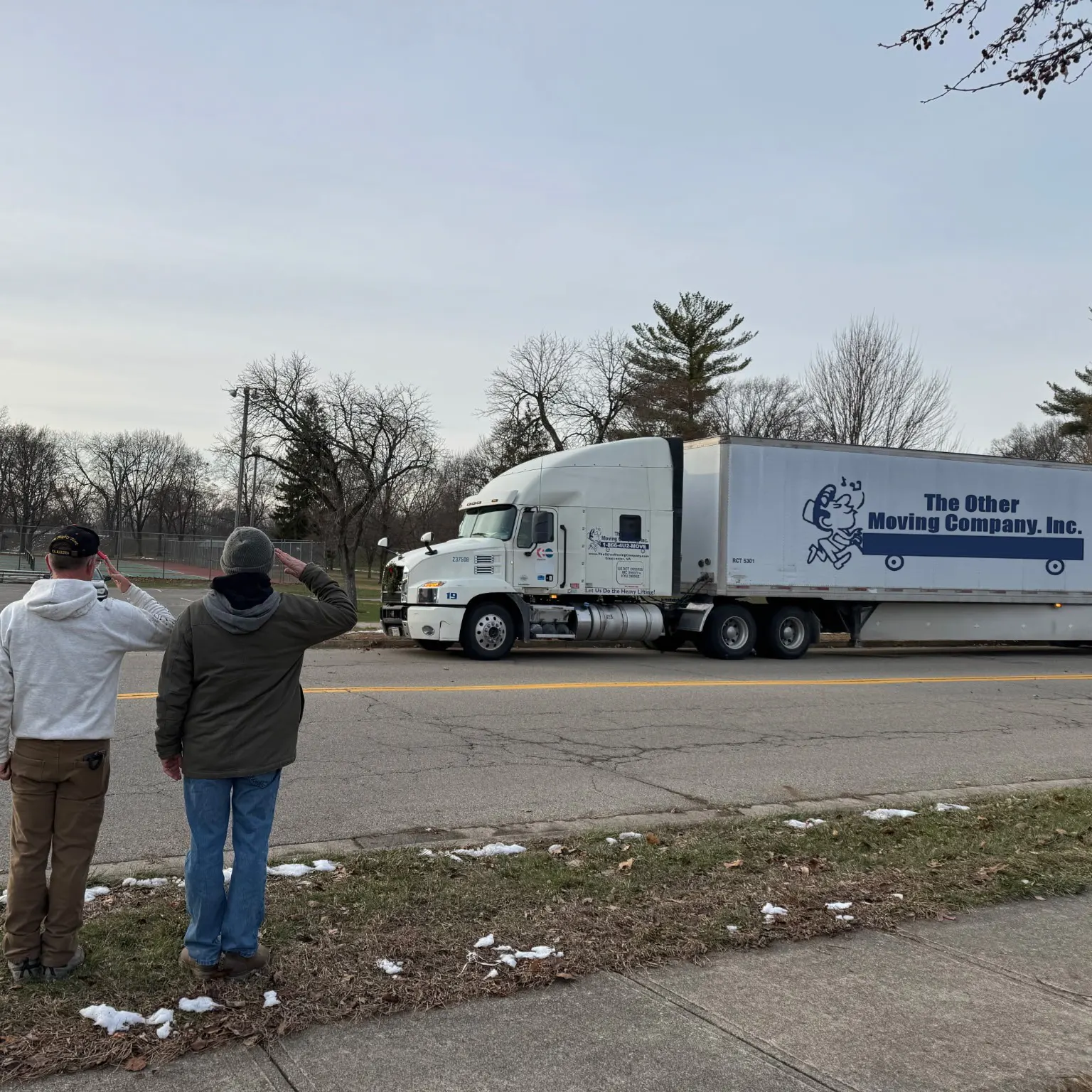 members of TOMCO saluting in front of the moving truck